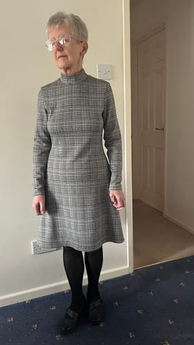Reviewer wearing a finished high-neck dress made from the Dogtooth Checkered Knit Fabric.
