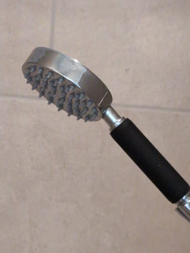 Customer's black Shark Skin Grip providing a secure hold on a handheld shower head.