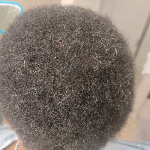 Customer shows a top-down view of thick, coily hair after using Rennora Hair Growth Serum.