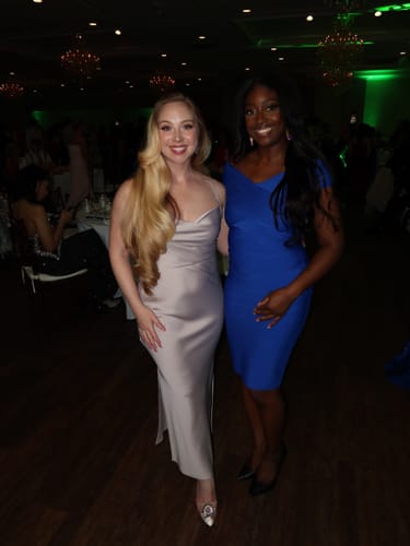 Reviewer wearing the blue Neoma Off Shoulder Bandage Dress at an event with a friend.
