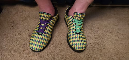 Reviewer wearing the Mardi Gras running shoes with mismatched purple and green shoelaces.