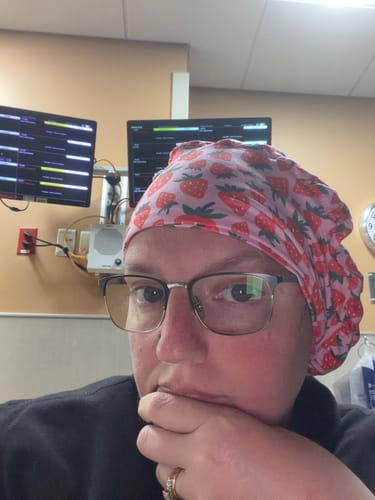 Reviewer in a medical setting wearing the pink DuoStyle Scrub Hat with a strawberry pattern.
