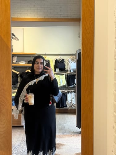 Reviewer taking a mirror selfie wearing the black Midnight Lace Modal hijab with its white lace trim.
