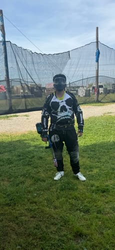 Reviewer wearing the PRO DNA™ DNA SERIES JERSEY with a skull graphic on a paintball field.