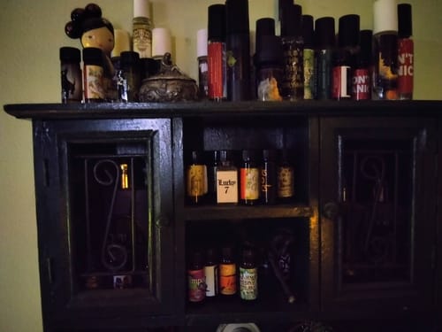 Customer's large collection of perfume bottles on a dark wooden cabinet, which includes We Are Stardust.