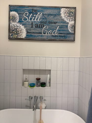 Customer's 'Be Still And Know That I Am God' sign hanging on a bathroom wall above a white tub.