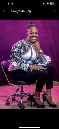 Customer seated and smiling, wearing the elegant black and white contrast flower print blouse.