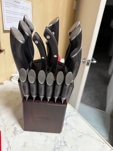 Customer's Japanese knife set with dark pakkawood handles neatly arranged in its wooden block on a kitchen counter.