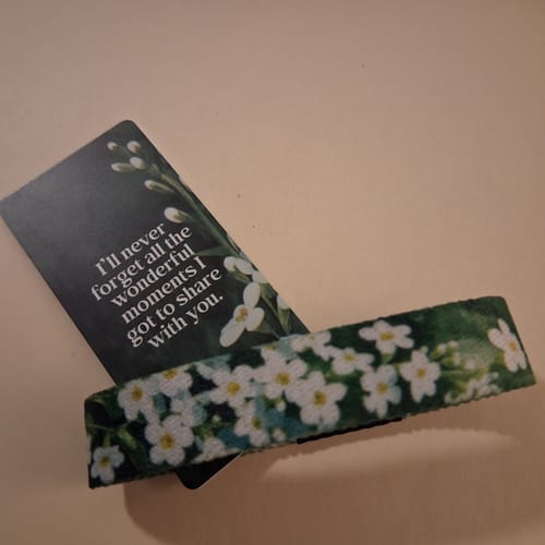 Customer's floral Special Memories Bracelet resting on a card with the message 'I'll never forget...'