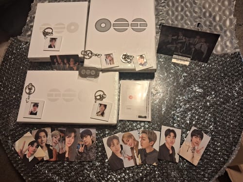 Customer's BTS Arirang 5th Album set displayed on bubble wrap, showing albums, photocards, and keychain gifts.