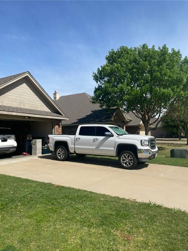 Customer's white Sierra 1500 truck parked in a driveway, showing the increased height from the 3" lift kit.