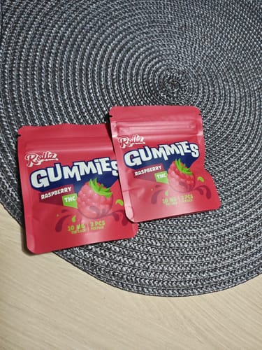 Customer's two pink pouches of ROLLZ THC gummies sitting on a textured grey placemat.