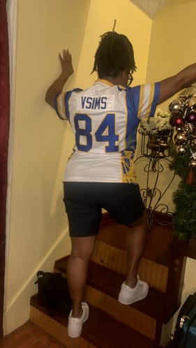 Reviewer from behind wearing a white and blue custom football jersey with 'VSIMS' and '84' on the back.