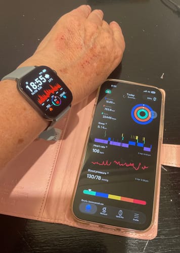Reviewer's Gard Pro Health Smartwatch 3 on their wrist, showing health data next to the companion app on a smartphone.
