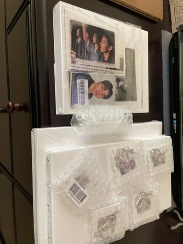 Customer's BTS ARIRANG 5th Album set laid out, showing the included photocards and bubble-wrapped keyrings.