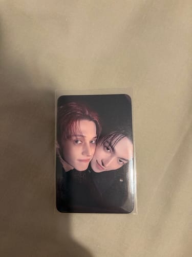 Customer's ATEEZ 'GOLDEN HOUR' photocard in a protective sleeve, showing two members in a close-up photo.