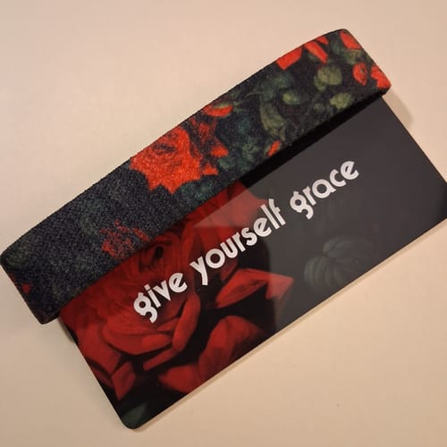 Reviewer's floral Give Yourself Grace Bracelet on its 'give yourself grace' backing card.