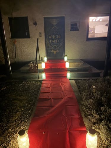 Customer's entryway decorated for the Masquerade Murder Mystery game with a red carpet and decorative lights.