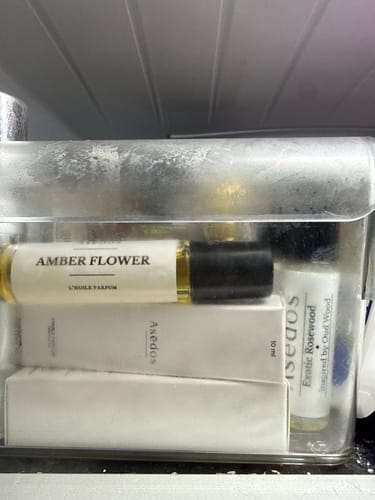 Customer's Amber Flower Perfume Oil roll-on bottle stored in a clear container on a refrigerator shelf.