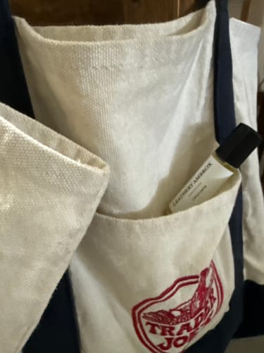 Customer's LEATHERY AMBROX PERFUME OIL roll-on bottle in the side pocket of a canvas tote bag.