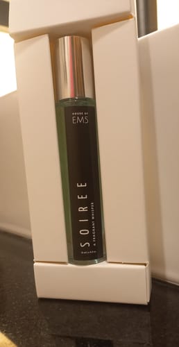 Customer's Soiree Eau De Parfum bottle with a black label, sitting inside its white packaging.