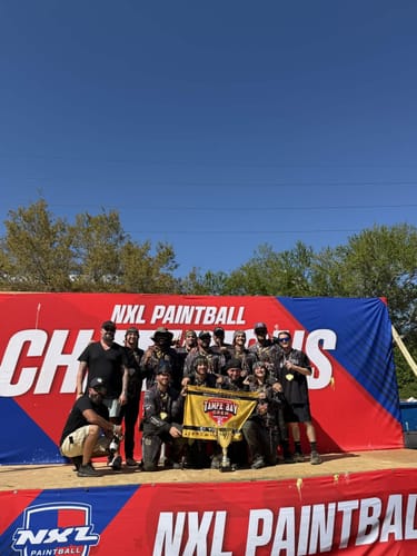 Customer's paintball team on the winners' podium celebrating a tournament win after using Voltanium Paintballs.