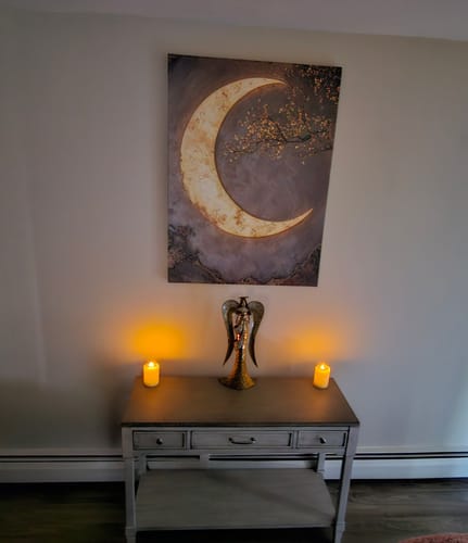 Customer's illuminated Crescent Moon Canvas creating a serene focal point above a console table with candles.