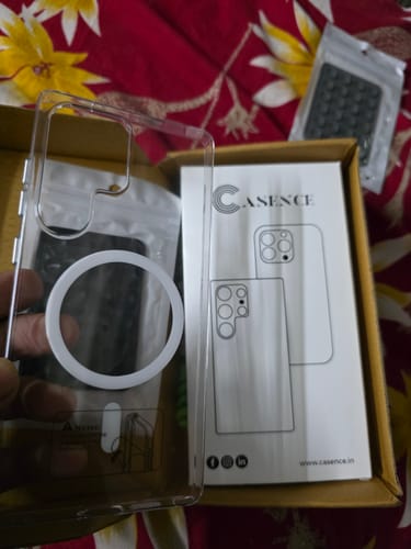 Customer holding the Anti Yellow Magsafe Clear Case, showing the packaging and the case's white magnetic ring.