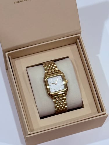 Customer's Macy Gold White watch with a gold link band and white face, presented in its box.