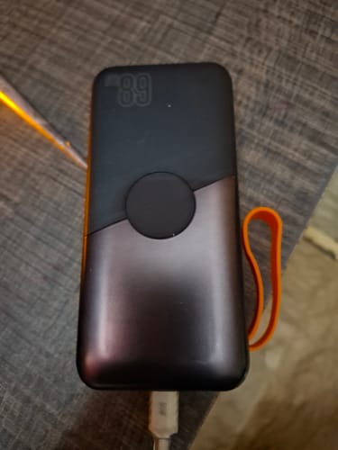 Customer's two-tone PD 68W Powerbank on a table, with the LED screen showing 89% battery life.
