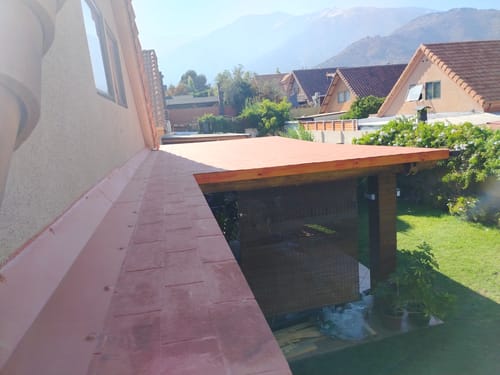 Cliente muestra el techo de una terraza recién sellado con el Sellador de Techos Coolguard en color teja.