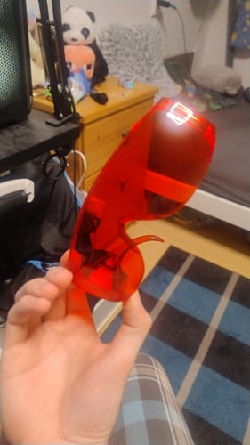 Customer holding up a pair of red VisionX glasses in their hand.