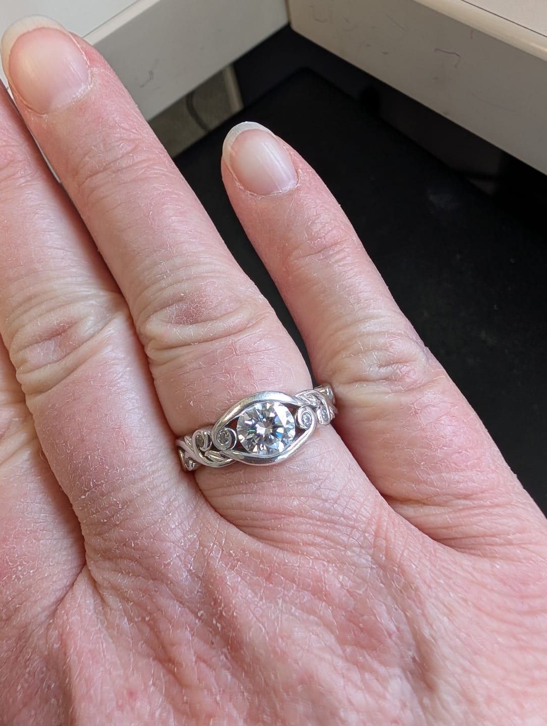 Customer photo review of Bezel Set Round Moissanite Scroll Accents Engagement Ring