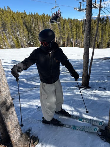 Reviewer skiing on a snowy slope wearing the baggy waterproof snow pants.