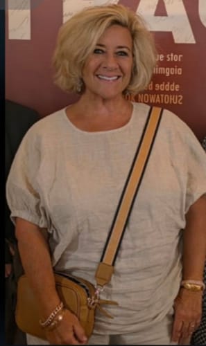 Reviewer smiling while wearing the light-colored Kristie Top, showing its relaxed fit and elasticated sleeves.