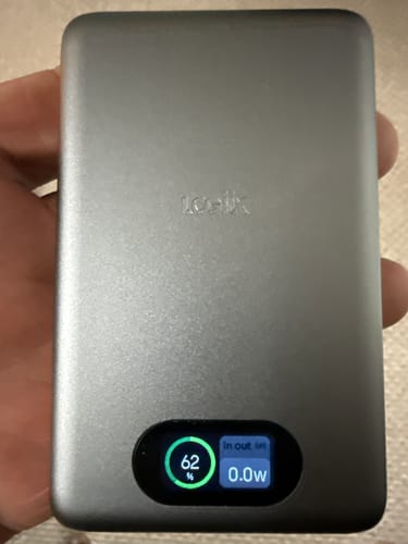 Customer holding the grey Piston Power 10,000 Pro Mag. Its digital display is on, showing 62% battery remaining.