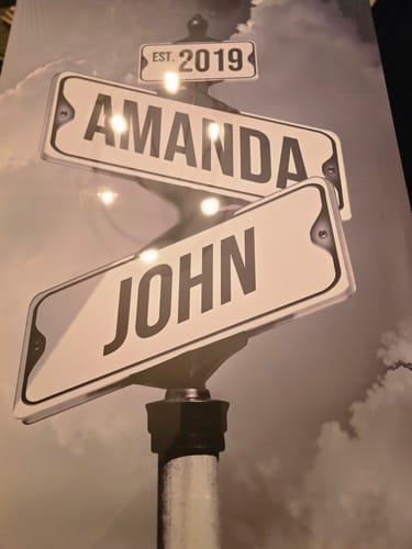 Customer's personalized canvas with vintage-style street signs for 'Amanda' and 'John' and a sign for 'EST. 2019'.