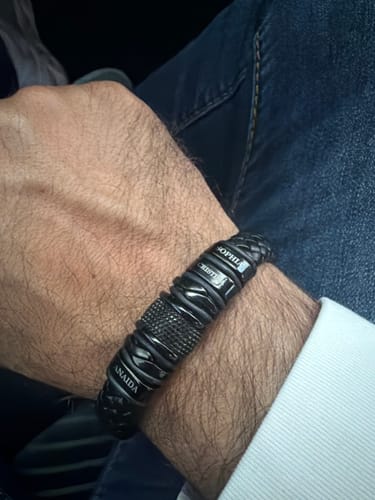 Customer's wrist wearing the personalized black bracelet with engraved names.