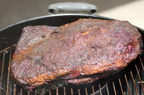 Primer plano del Pecho Pieza Básica de un cliente, ahumado y sobre una parrilla redonda.