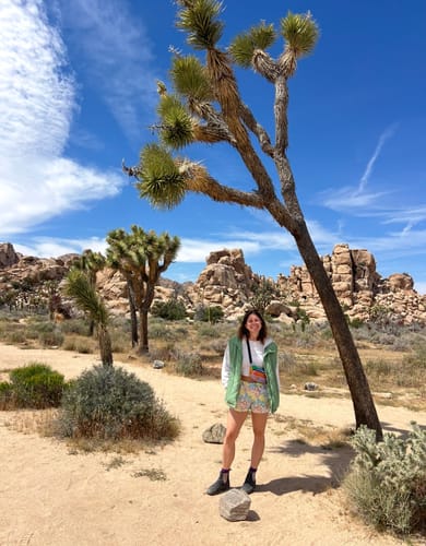 Reviewer standing in a desert landscape wearing colorful Patagonia Barely Baggies Shorts.