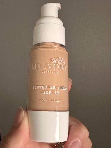 Customer holding a pump bottle of Tinted BB Cream SPF 15 in the Fair Light shade.