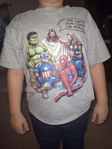 Customer wearing the grey 'How I Saved The World Youth' t-shirt, showing the graphic with Jesus and superheroes.