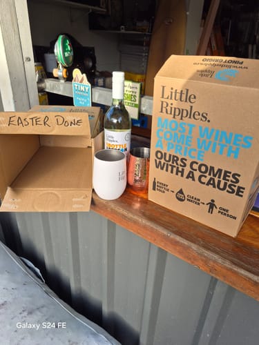 Customer's bottle of Pinot Grigio and 6-pack box on a counter, next to an empty box marked 'EASTER DONE'.