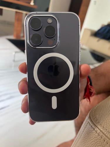 Reviewer holding an iPhone 14 Pro in the clear Anti Yellow Magsafe Case, showing the white MagSafe ring.
