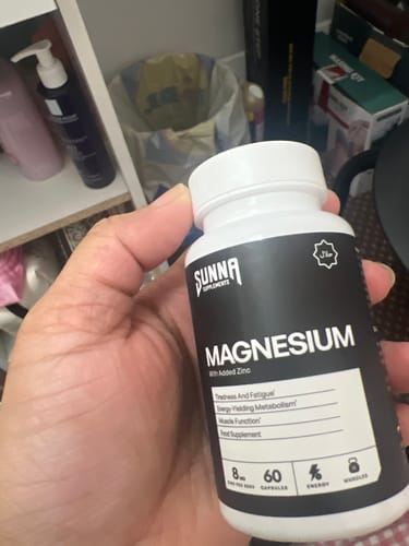 Customer holding a white bottle of Sunna Supplements Magnesium with Added Zinc.