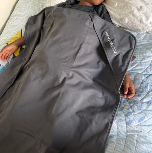 Customer's child resting in bed while covered with the grey Radproof baby blanket.