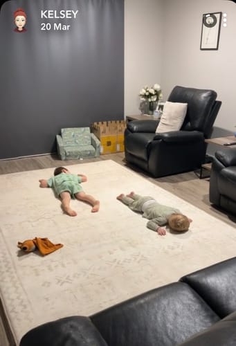 Customer's review photo of two children lying comfortably on the soft Sandstone Haze Mellow Mat in a living room.