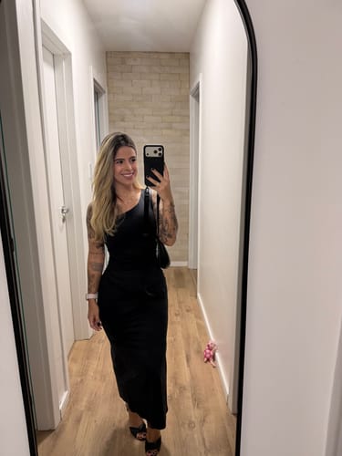 Avaliadora tira uma selfie no espelho, mostrando a Case preta que combina com seu look.