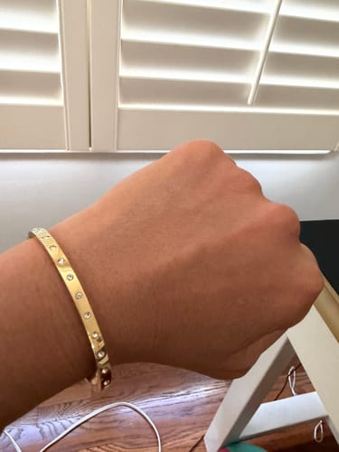 Reviewer wearing the sparkly, gold Eternity Bangle Slim on their wrist.