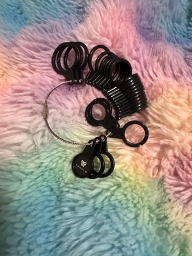 Reviewer's black Thorum Ring Sizer laid out on a colorful, fluffy surface.